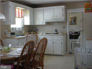 44 Champlain Road Marlton, NJ 08053 - Photo 5 of 6 a kitchen with stainless steel appliances granite countertop a sink a stove a dining table and chairs with wooden floor