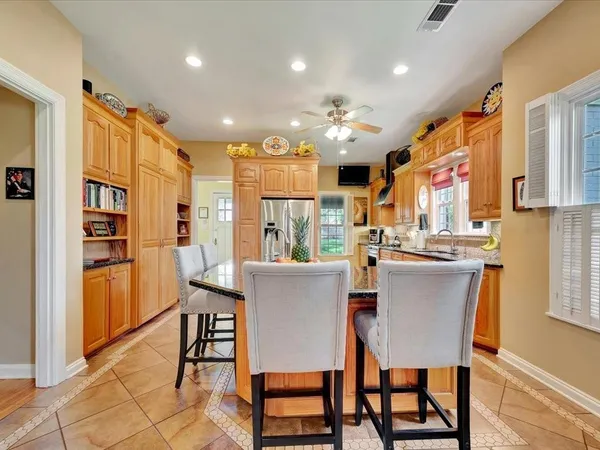 a dining room with stainless steel appliances kitchen island granite countertop a dining table chairs and view kitchen