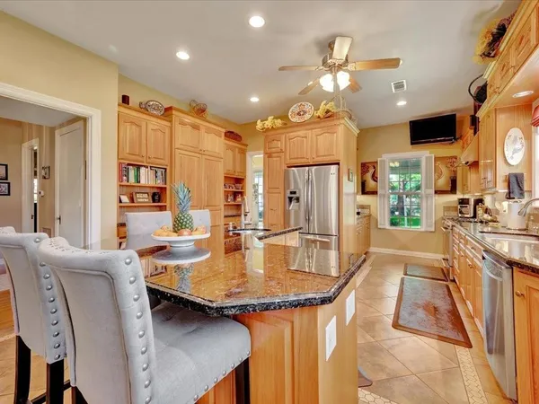 a kitchen with stainless steel appliances granite countertop furniture stove top oven and refrigerator
