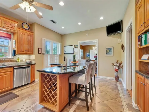 a kitchen with stainless steel appliances kitchen island granite countertop a table and chairs in it