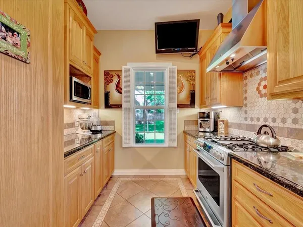 a kitchen with stainless steel appliances granite countertop a stove a sink and a microwave