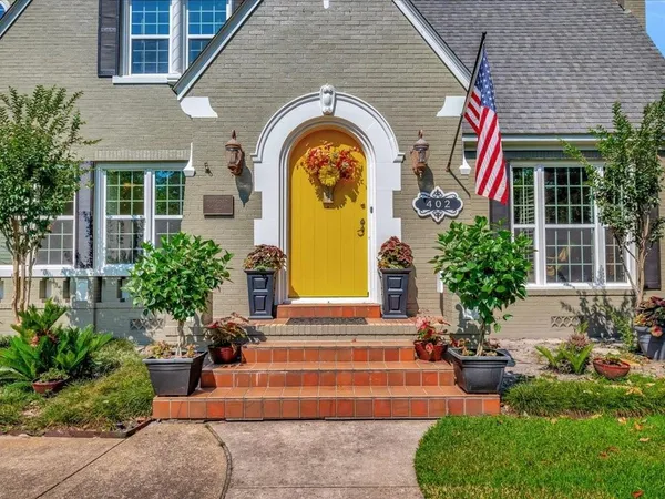 a front view of a house with lots of garden and plants