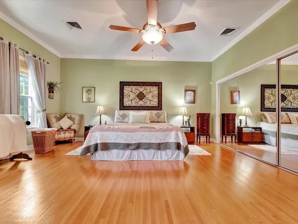 a spacious bedroom with a large bed and a chandelier