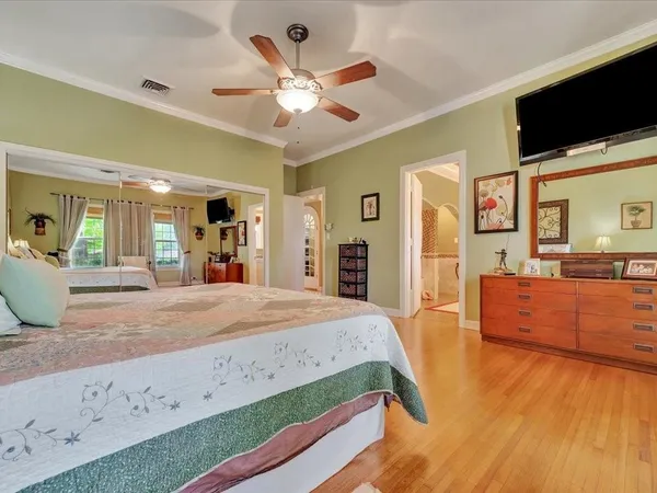 a spacious bedroom with a bed and a flat screen tv