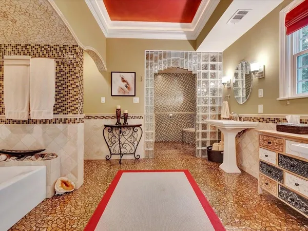 a bathroom with a tub sink and mirror
