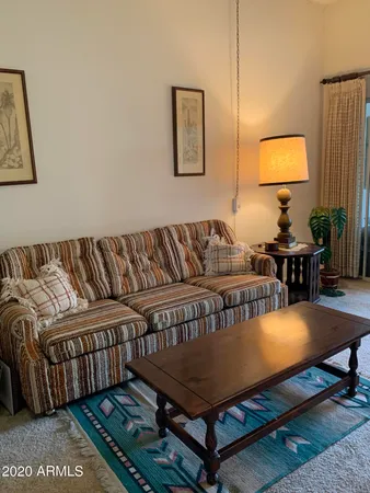 a living room with a couch and paintings on the wall