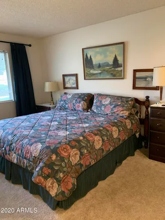 a bedroom with a bed dresser and window