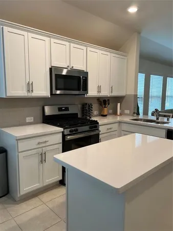 a kitchen with stainless steel appliances a stove a sink a microwave and cabinets