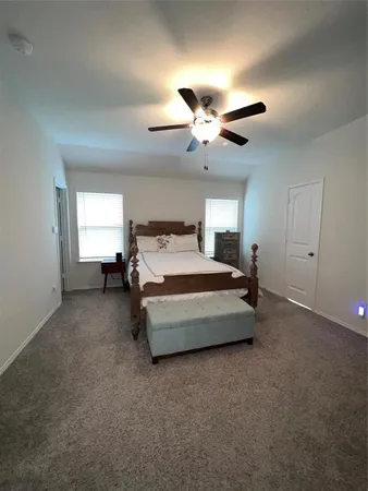 a spacious bedroom with a bed and window