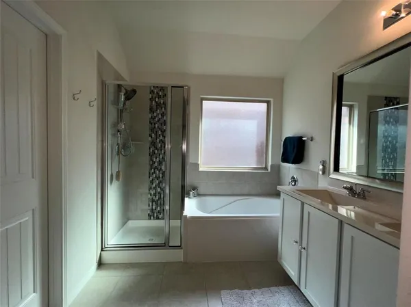 a bathroom with a bathtub sink and mirror