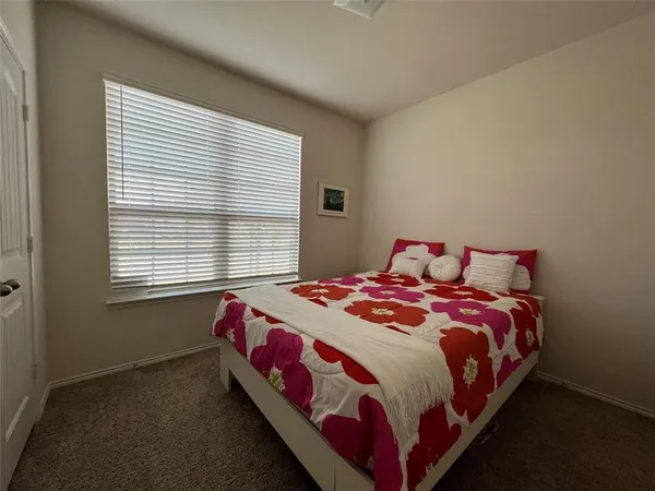 a bedroom with a bed next to a window