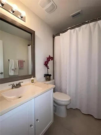 a bathroom with a sink a toilet and shower curtain