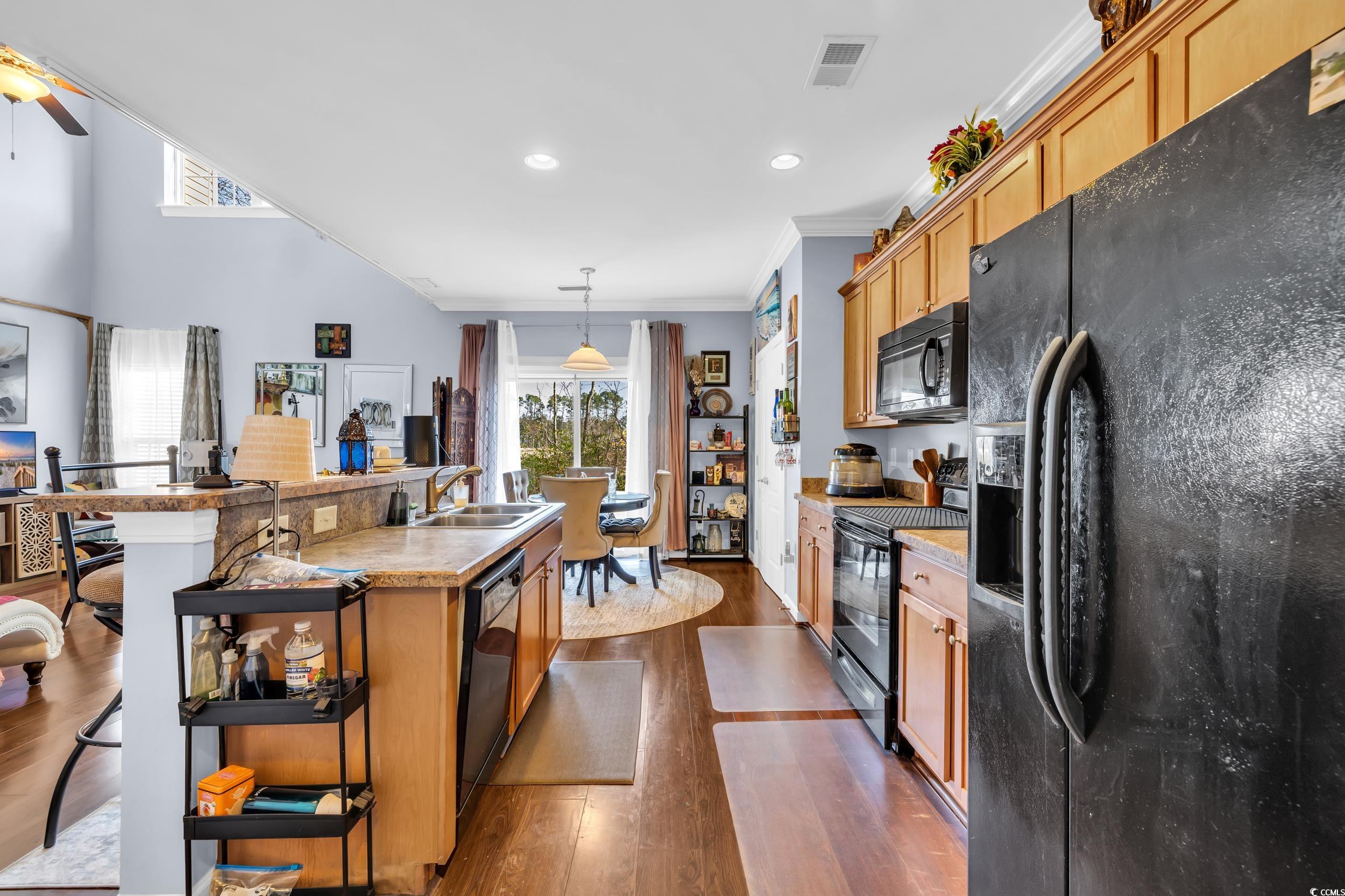1040 Fairway Lane, Unit 1040 Conway, SC 29526 - Photo 10 of 28 Kitchen featuring sink, a center island with sink, dark hardwood / wood-style flooring, pendant lighting, and black appliances