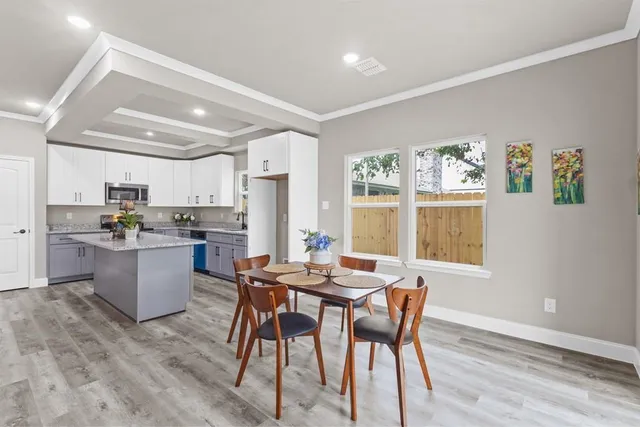 a kitchen with a dining table chairs and refrigerator