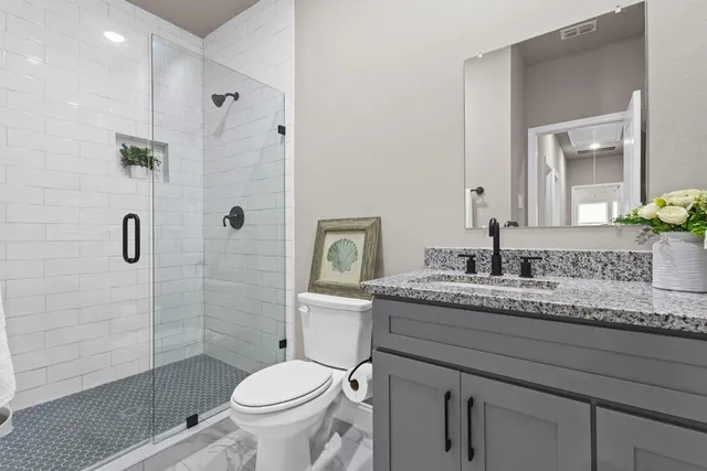 a bathroom with a granite countertop toilet sink and shower