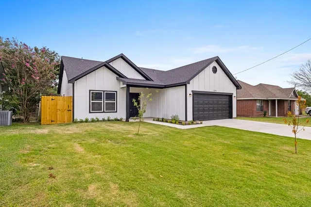 a front view of a house with yard and garage