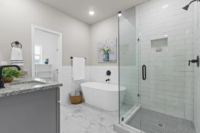 a bathroom with a granite countertop sink a toilet and shower