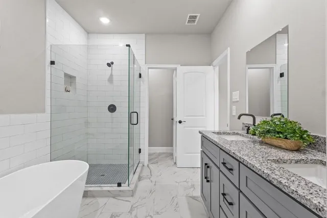 a bathroom with a granite countertop tub sink and mirror
