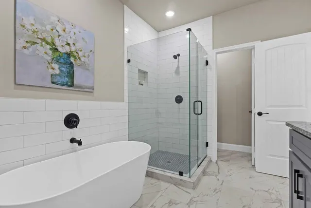 a bathroom with a bathtub a shower and a sink