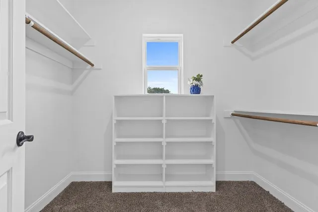 a view of walk in closet with empty racks