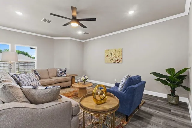 a living room with furniture a window and a potted plant