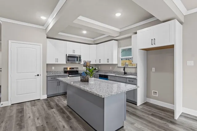a large kitchen with cabinets stainless steel appliances and a counter space