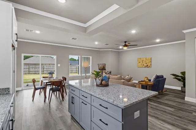 a kitchen with a table chairs and wooden floor