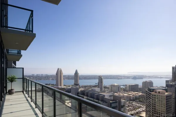 a bedroom with a bed and a large window with balcony view