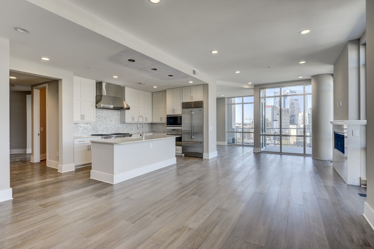 20 Rutledge Street, Unit 601 Nashville, TN 37210 - Photo 12 of 30 a large kitchen with stainless steel appliances granite countertop a large counter top a refrigerator and cabinets with wooden floor