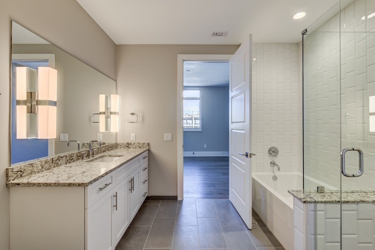 20 Rutledge Street, Unit 601 Nashville, TN 37210 - Photo 9 of 30 a spacious bathroom with a granite countertop sink a mirror and a shower