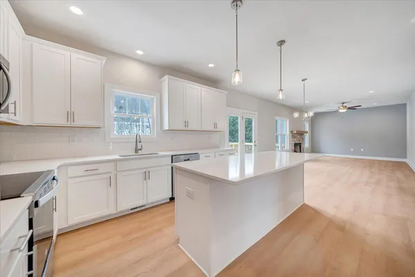 a large kitchen with kitchen island a sink stainless steel appliances and cabinets