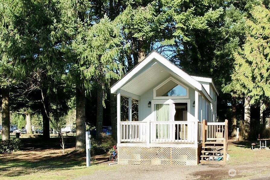150 Happy Trails Road, Unit 119 Castle Rock, WA 98611 - Photo 2 of 20 a view of a white house with large windows and a small yard