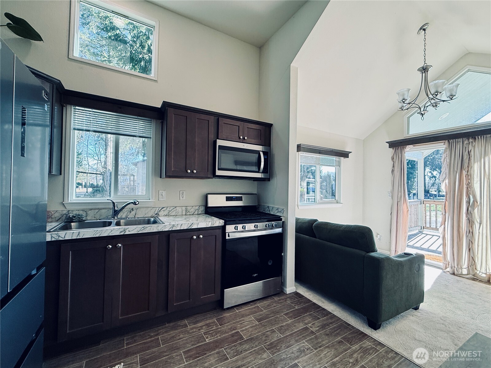 150 Happy Trails Road, Unit 119 Castle Rock, WA 98611 - Photo 5 of 20 a kitchen with stainless steel appliances granite countertop a stove a sink dishwasher and a microwave oven with wooden floor