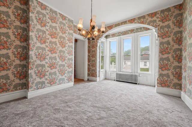 a view of a big room with windows and chandelier
