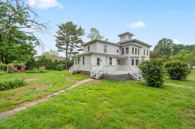 a front view of a house with yard and green space