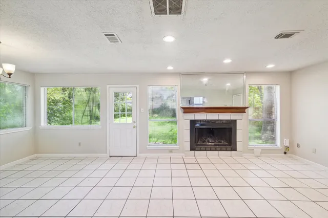 an empty room with windows and fireplace