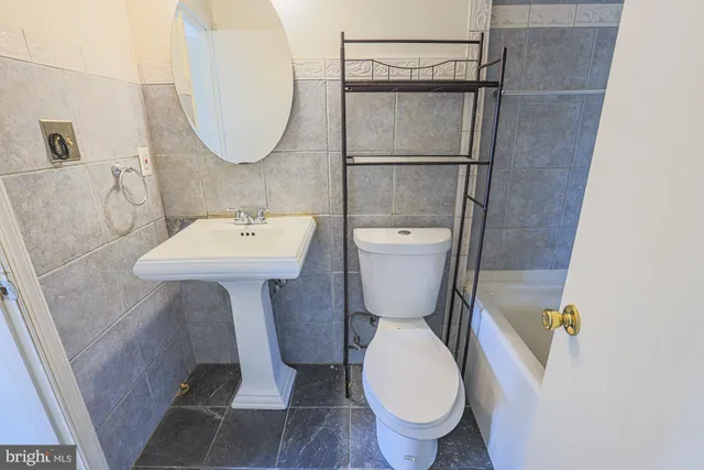 a bathroom with a sink toilet and a mirror