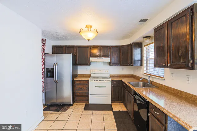 a kitchen with a refrigerator a sink and cabinets