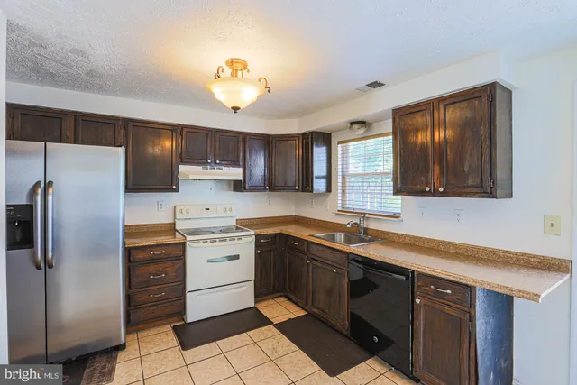 a kitchen with a sink cabinets and stainless steel appliances