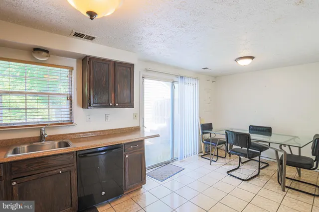 a kitchen with a sink and chairs