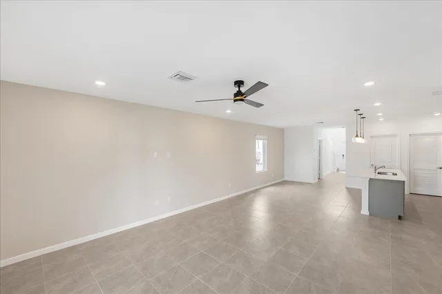 an empty room with a window and a ceiling fan
