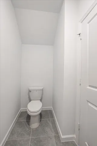 a white toilet sitting next to a shower