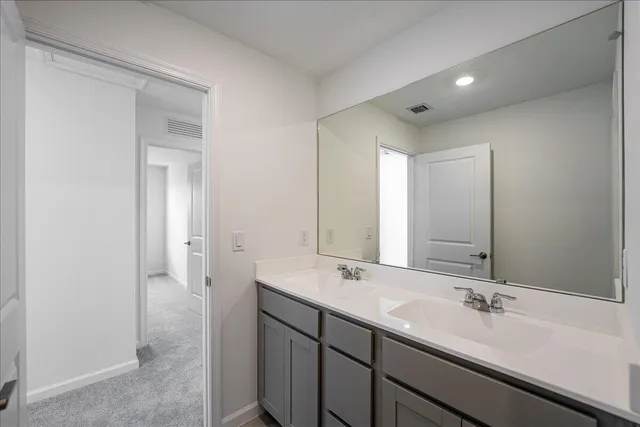 a bathroom with a double vanity sink and mirror