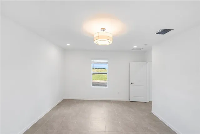 an empty room with window and ceiling fan