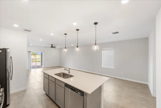 a kitchen that has a sink a refrigerator and a stove