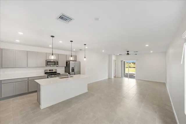a large kitchen with cabinets and wooden floor