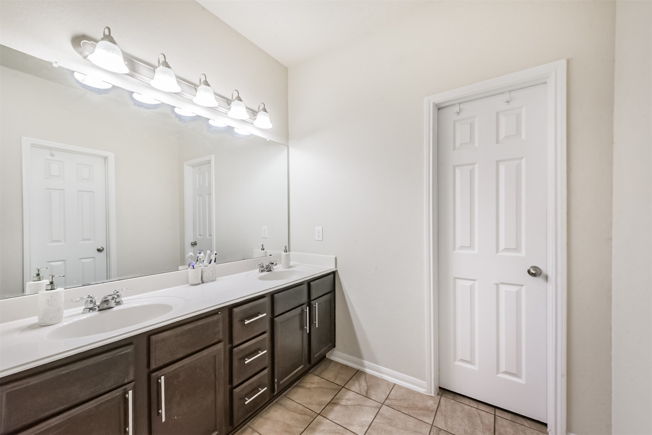 14723 Nickel Plank Road Houston, TX 77049 - Photo 23 of 47 a bathroom with a double vanity sink and a mirror