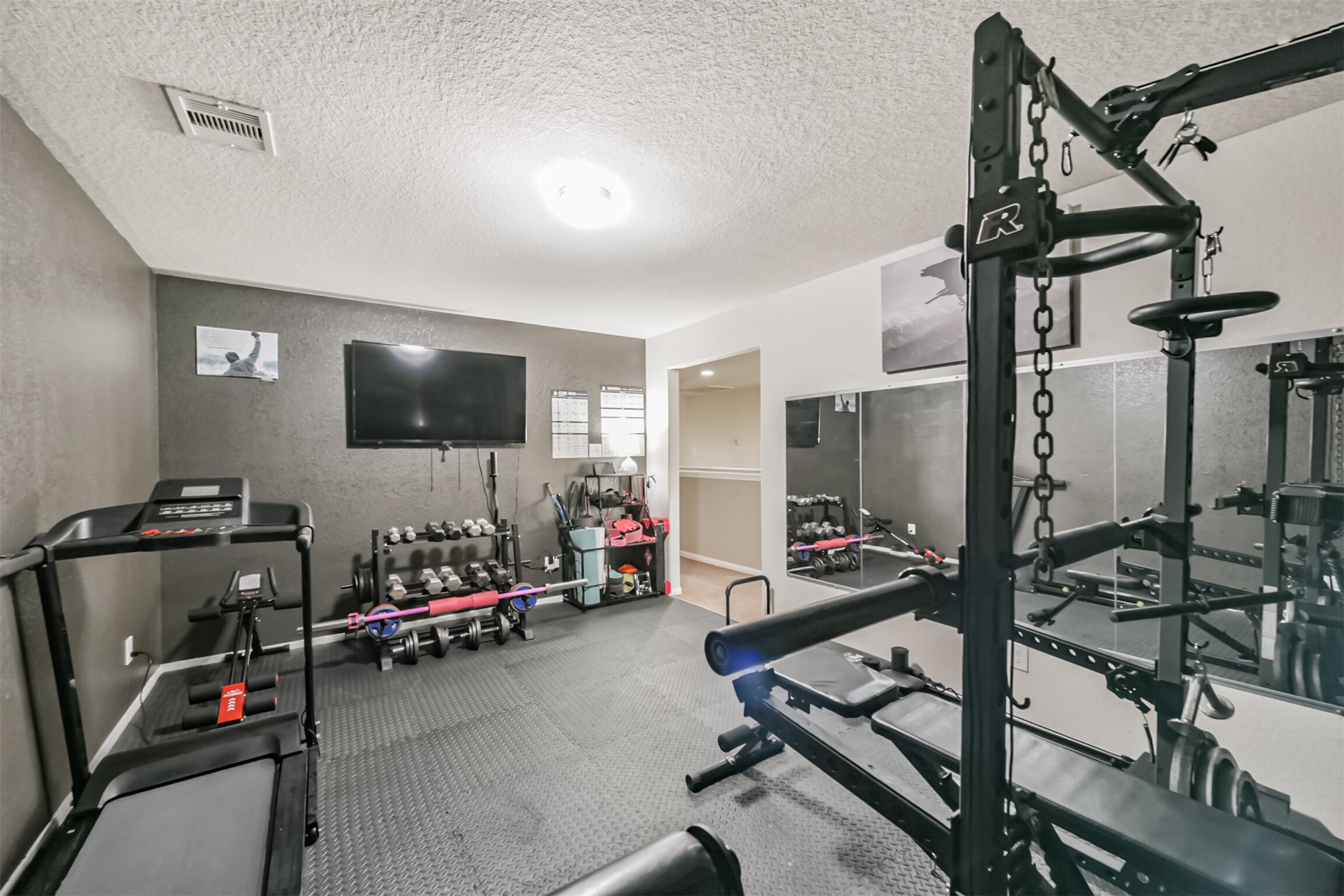 14723 Nickel Plank Road Houston, TX 77049 - Photo 30 of 47 a room with gym equipment and a flat screen tv
