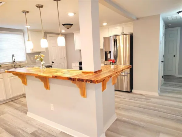 a view of a kitchen with kitchen island a sink a counter top space and living room view