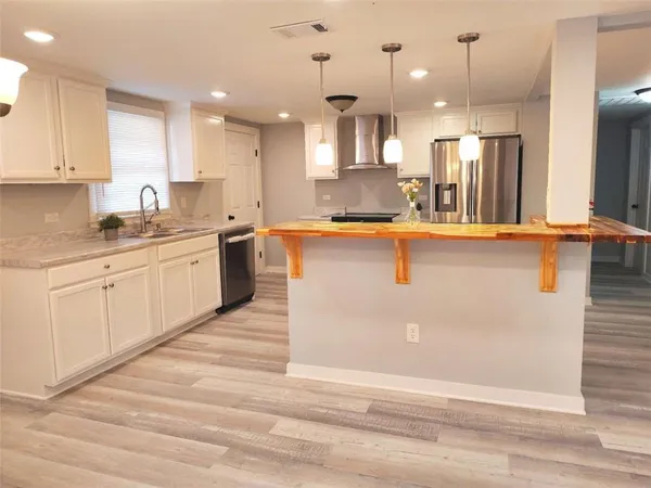 a large kitchen with granite countertop a sink a stove and cabinets